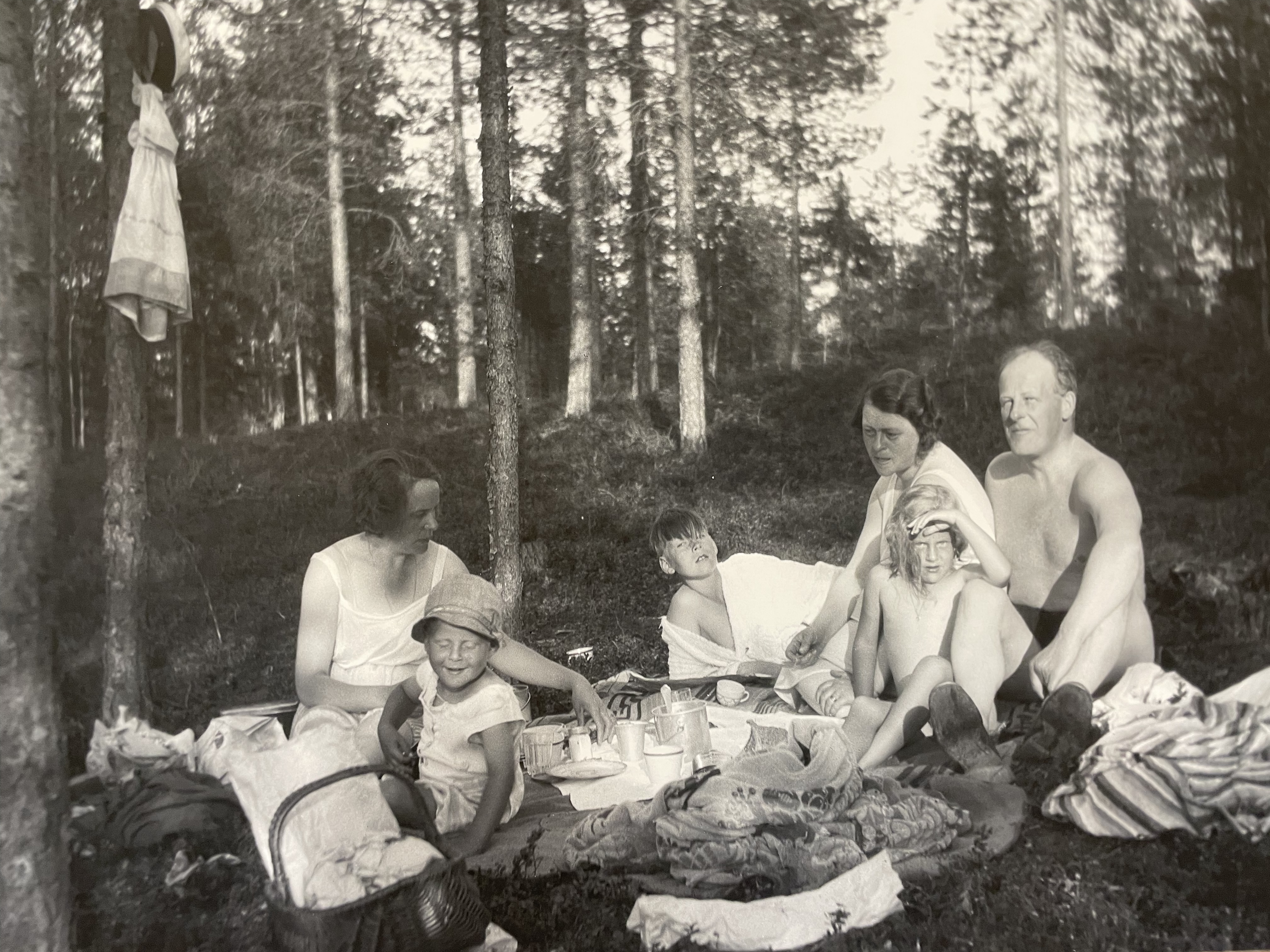 Svartvitt fotografi på familj som har semester i skogen